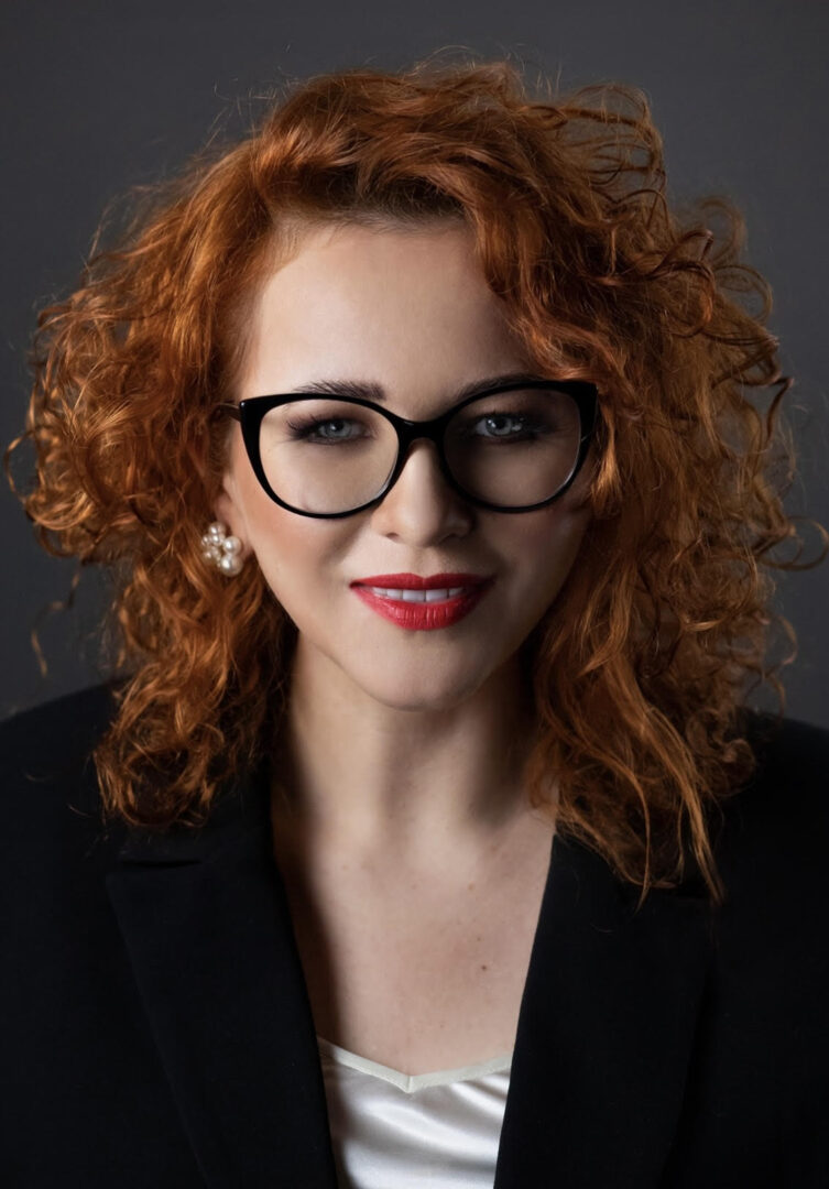 Uśmiechnięta kobieta z rudymi bujnymi lokami..