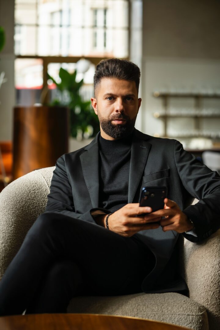 Elegancki mężczyzna. Siedzi w fotelu.